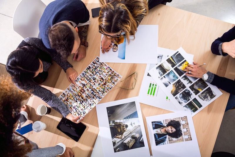 Designers at work reviewing prints top down close up